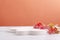 Closup of white stand and colorful decorative branches on the white table against bright orange wall.Empty space