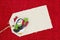 A cloth gift tag with a Christmas penguin on shiny red material