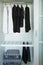 Clothes hang on a shelf in a designer clothes store, modern closet with row of cloths hanging in wardrobe, vintage rooms