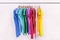 Clothes hanging on clothing rack wardrobe fashion apparel selection of rainbow color t-shirts on closet hangers. Womens