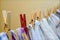 Clothes pegs on a string holding laundry - yellow clothes pins and one in focus red closeup