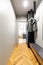 Clothes on rack above countertop in anteroom interior with wooden floor and light. Real photo