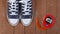 Clothes shoes and sport - top view fragment pair blue gumshoes and Red Stopwatch wooden background