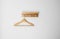 Clothes wooden hanger on a white wall.