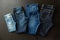 Clothing - family jeans on black. Various denim trousers from above
