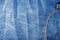 clothing items blue stonewashed faded jeans cotton fabric texture with seams, clasps, buttons and rivets, macro, close-up