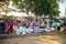 A clothing market on a dirty street in a Kenyan village. Lots of clothes, household items and caged chickens