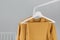 Clothing rack with stylish autumn outfit. Yellow, mustard color linen jacket, shirt and pajamas trousers dress on