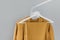 Clothing rack with stylish autumn outfit. Yellow, mustard color linen jacket, shirt and pajamas trousers dress on