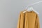 Clothing rack with stylish autumn outfit. Yellow, mustard color linen jacket, shirt and pajamas trousers dress on