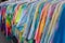 Clothing rack of tie dye and colorful tourist t-shirts for sale at a gift shop