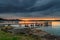 Cloud covered sunrise waterscape over the bay with wharfs