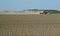 Cloud of dust behind a ploughing tractor during springtime in Zeeland