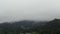 Cloud floating over a village and mountain. Misty fog blowing over tree forest. Raining forest, foggy on the canopy in rainforest