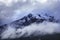 Cloud and ice on peak of rock mountain in arthur`s pass national park new zealand