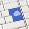 Cloud icon in blue on a white computer keyboard