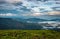 Cloud layers on mountain horizon with green grass