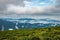 Cloud layers on mountain horizon with green grass