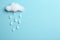 Cloud and raindrops made of cotton on blue background