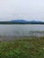 Cloud shrouded mountain seen from the edge of the reservoir