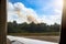 Cloud of thick smoke in the mountains. View from the airplane window