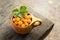 Cloudberries in wooden kuksa mug. Cup of delicious cloudberries stands on the wooden table