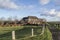 Clouded sky above farmhouse with fence and road in polder near river IJssel