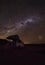 Cloudless starlit night sky with Milky Way and bright stars with a 4WD vehicle with roof tent in front as panorama view