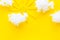 Cloudly weather concept. Sun and clouds on yellow background top view copy space