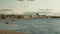 Clouds above buildings on waterfront and boats on river