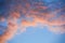 The clouds in the blue sky are illuminated by the orange setting sun. Natural background