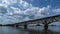 Clouds in the blue sky over a steel bridge