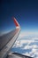 Clouds, blue sky and the wing of a jet passenger plane photo from the porthole. Travel and flights by plane.