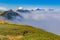 Clouds cover mountain tops at autumn evening time.