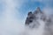 Clouds cover the rocky summit. Rocky Mountains