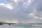 Clouds and distant rain above a churning sea