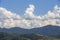 Clouds in dramatic formation over the chain of hills, with blue sky