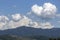 Clouds in dramatic formation over the chain of hills, with blue sky