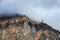 Clouds float on high mountains near the Aktru glacier, rock ledges formed by glaciers