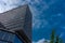 Clouds fly across a blue sky over a glass windowed building at B