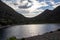 Clouds between hills behind a lake all silhouetted