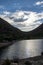 Clouds between hills behind a lake all silhouetted