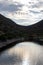 Clouds between hills behind a lake all silhouetted