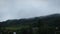 Clouds moving fast over mountains in dusk. Rainy stormy clouds against green mountain hills. Fluffy clouds in mountains