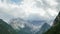 Clouds are Moving over the Peaks of the Alpine Mountains and a mountain lake. TimeLapse