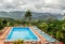 Clouds over green Vinales valley and blue swimming pool with dec