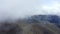 Clouds over mountain valley view from flying drone. Misty haze covering highlands aerial view. Spring mountain expanses in foggy h
