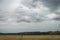 Clouds over scenic hills and meadows. Cloudy day in a picturesque summer valley