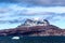 Clouds over Sermitsiaq mountain peaks covered in snow with blue