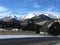 Clouds over snow capped mountain peaks and road.
